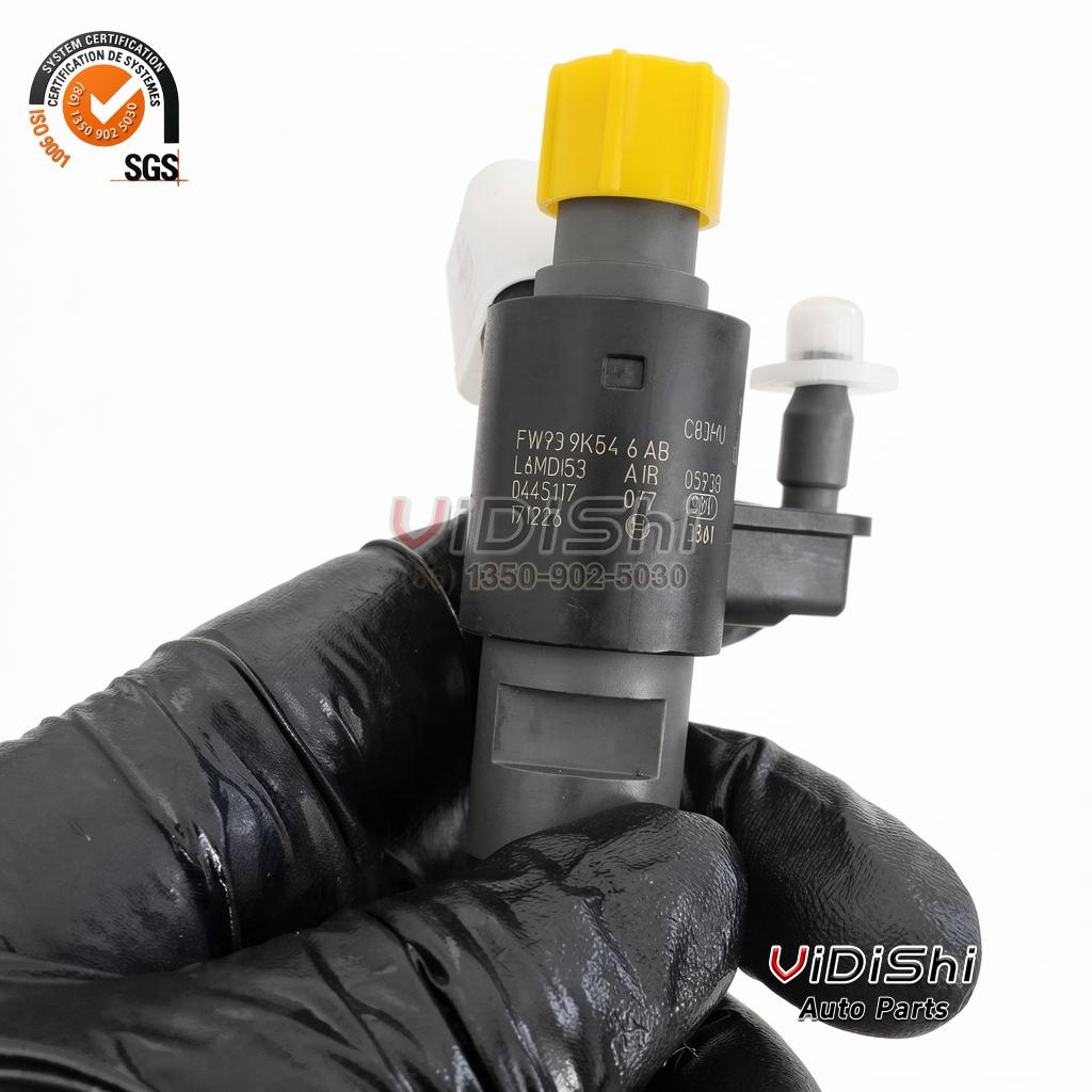 A 0445117077 injector held in a gloved hand showing the stamped body number and the maker code