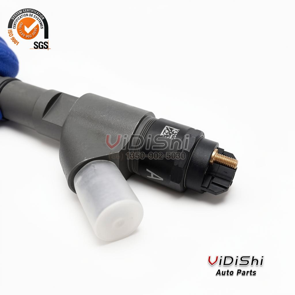 The black connector block of a 0445120067 injector with a data matrix label and a clear cap on the inlet union