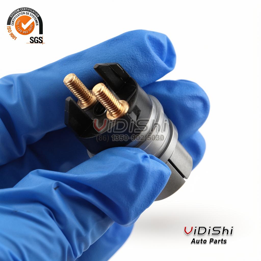 All Products 7 A gloved hand holding an F00RJ02702 solenoid valve with the two brass terminals facing the camera